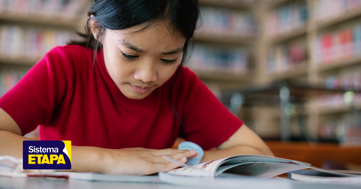 Menina de vermelho estudando.