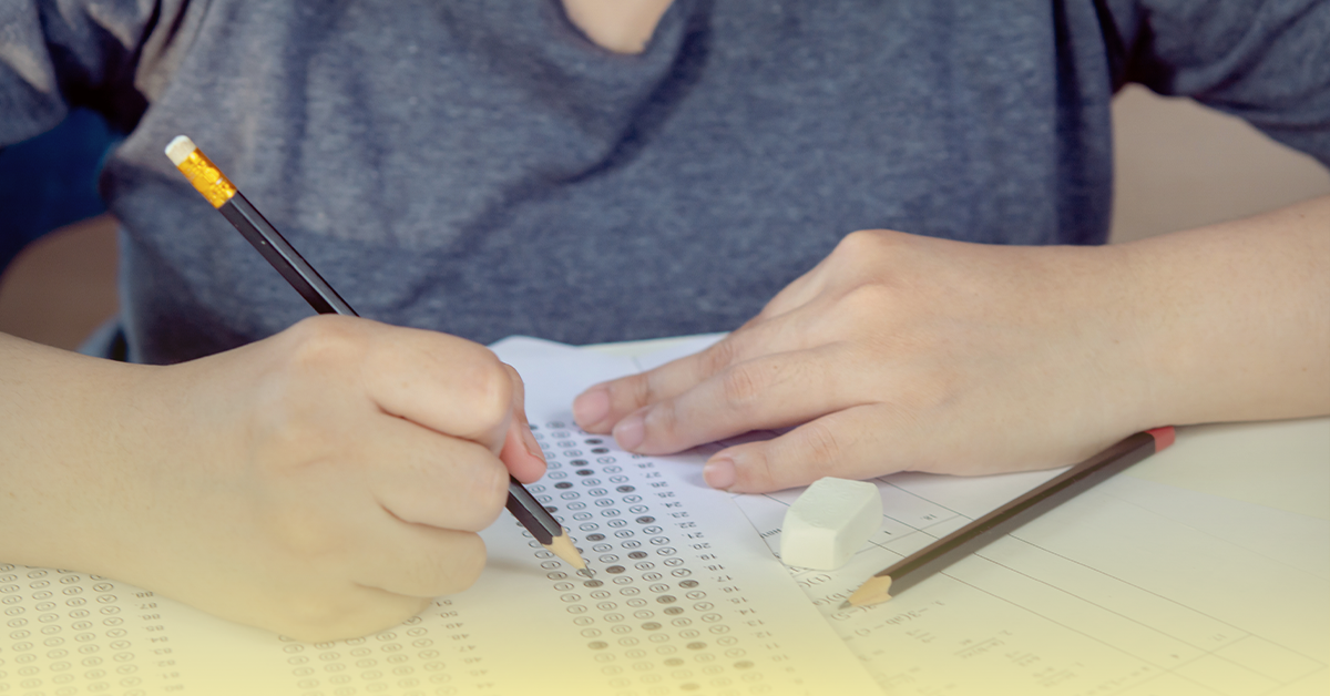 Estudante preenchendo caderno de provas de matemática para o Enem, focado na preparação para a prova de matemática do exame.